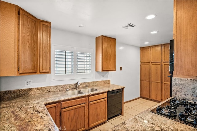 kitchen with light stone countertops, black appliances, light tile patterned floors, and sink