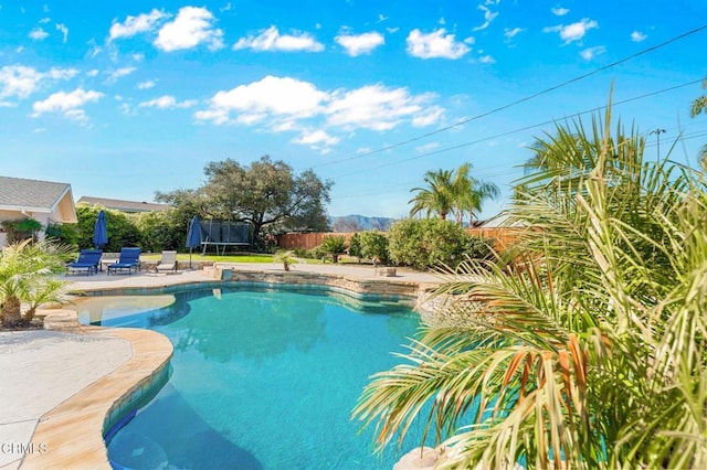 view of pool with a fenced in pool, a patio, a trampoline, and fence