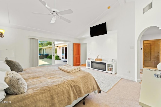 bedroom with visible vents, carpet floors, high vaulted ceiling, arched walkways, and access to exterior