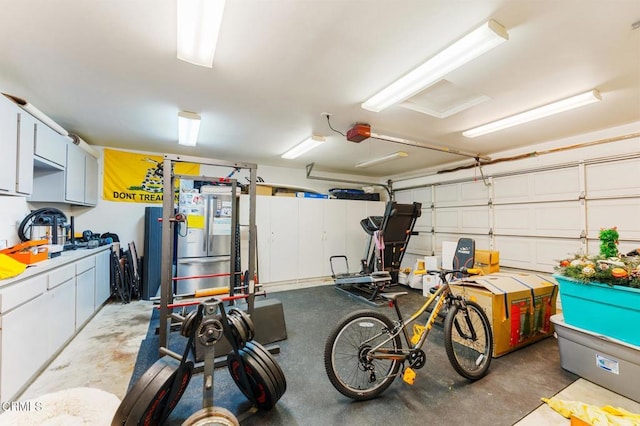 garage featuring a garage door opener and freestanding refrigerator