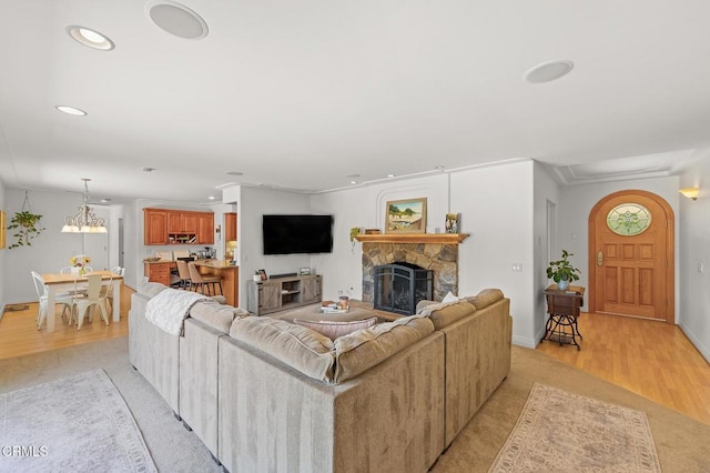 living area featuring recessed lighting, light wood-style flooring, a fireplace, and baseboards