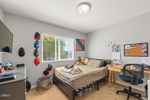 bedroom with light colored carpet and baseboards