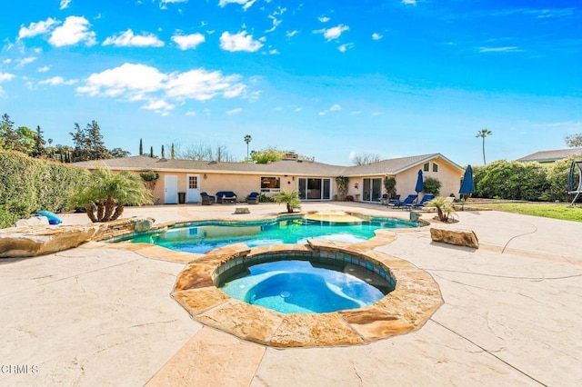 view of pool featuring a patio and a pool with connected hot tub