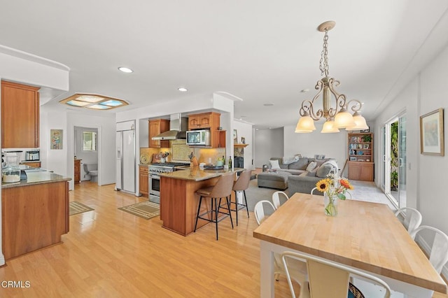 dining room with a notable chandelier, recessed lighting, and light wood-type flooring