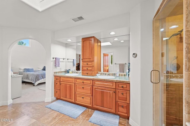 bathroom with visible vents, double vanity, a sink, a shower stall, and ensuite bathroom