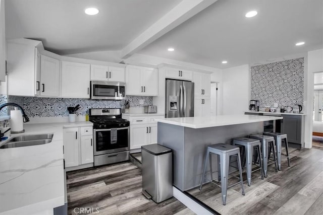 61853 Grand View Cir, Joshua Tree, CA 92252 - kitchen featuring a sink, light wood-type flooring, a breakfast bar, stainless steel appliances, and vaulted ceiling with beams