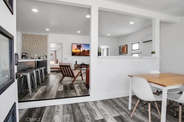 dining space featuring hardwood / wood-style flooring and a wall mounted air conditioner