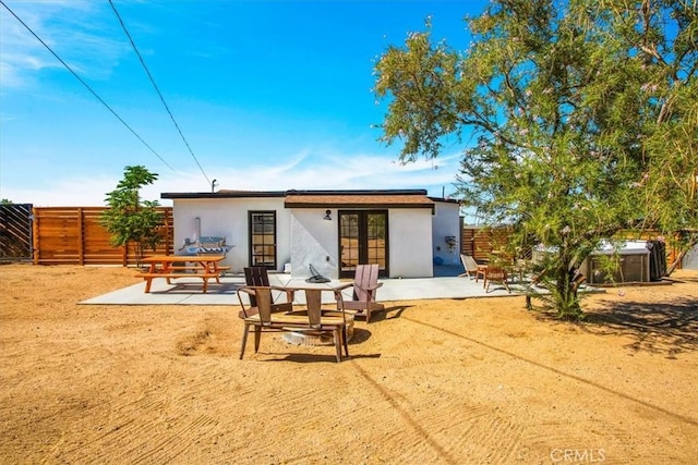 61853 Grand View Cir, Joshua Tree, CA 92252 - back of property featuring french doors, a patio area, stucco siding, and a fenced backyard