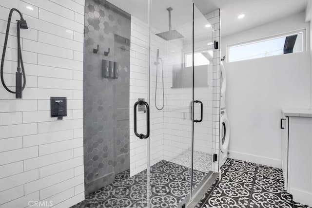 bathroom featuring tile patterned flooring, washer / clothes dryer, and walk in shower