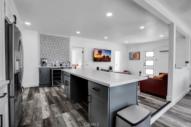 kitchen with beverage cooler, dark hardwood / wood-style floors, stainless steel fridge with ice dispenser, and gray cabinetry