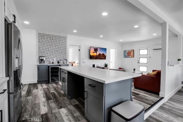 61853 Grand View Cir, Joshua Tree, CA 92252 - kitchen with a wall mounted AC, stainless steel refrigerator with ice dispenser, beverage cooler, and dark wood-style floors