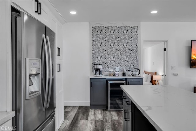 kitchen featuring wine cooler, dark hardwood / wood-style floors, white cabinets, stainless steel refrigerator with ice dispenser, and light stone countertops