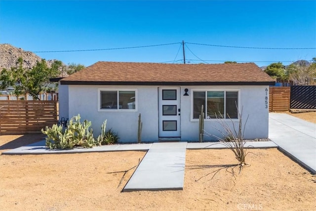 61853 Grand View Cir, Joshua Tree, CA 92252 - view of front of home featuring fence, a shingled roof, and stucco siding