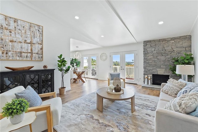 living area featuring french doors, a fireplace, recessed lighting, wood finished floors, and baseboards