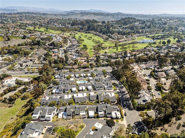 drone / aerial view featuring a residential view, view of golf course, and a mountain view