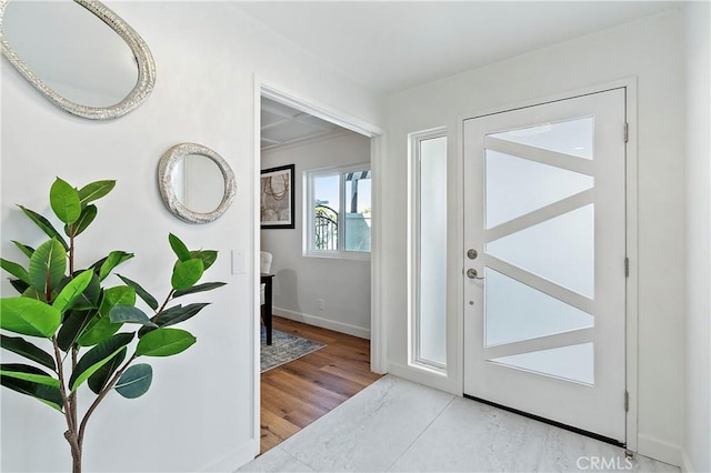 doorway with baseboards and wood finished floors