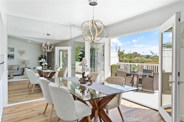 dining area with an inviting chandelier, a wealth of natural light, and wood finished floors