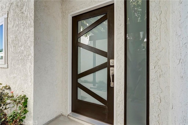 doorway to property featuring stucco siding