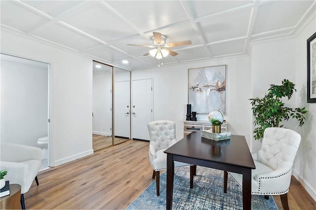 office space featuring baseboards, coffered ceiling, light wood-style flooring, and a ceiling fan