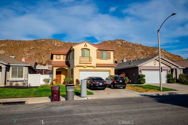 view of front of house featuring a mountain view, a front lawn, and a garage