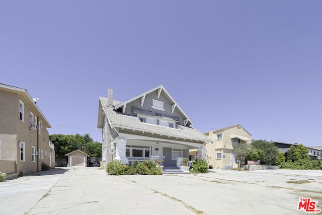 craftsman house with a porch, a garage, and an outdoor structure