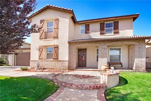 mediterranean / spanish-style home featuring a front lawn and a garage