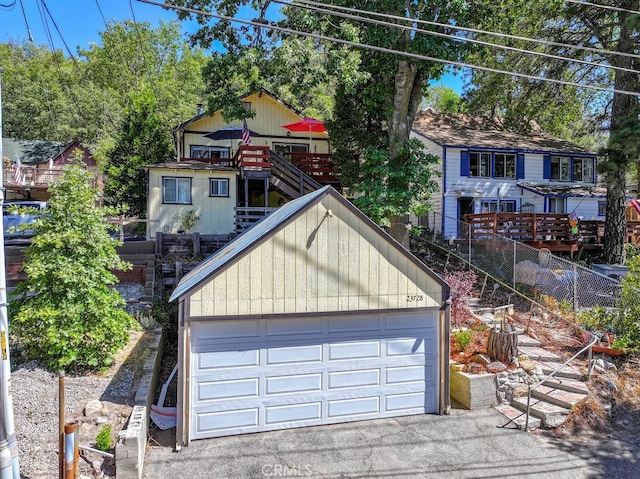 view of front of home with a garage, an outdoor structure, and a deck