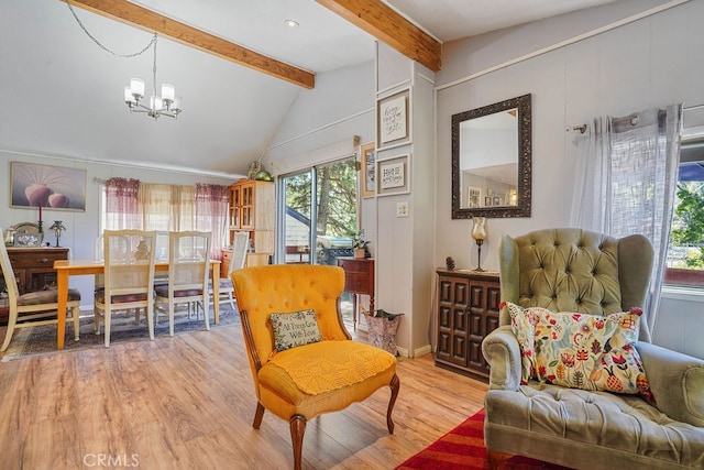 sitting room with lofted ceiling with beams, light wood-type flooring, and a chandelier