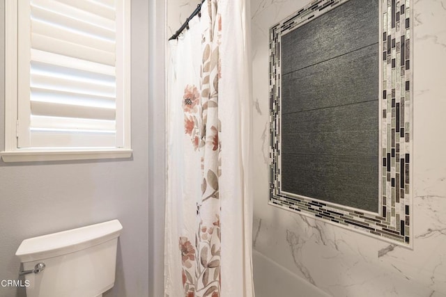 bathroom featuring a shower with curtain and toilet