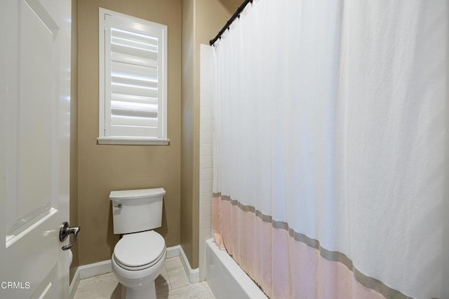 bathroom featuring shower / bath combination with curtain and toilet