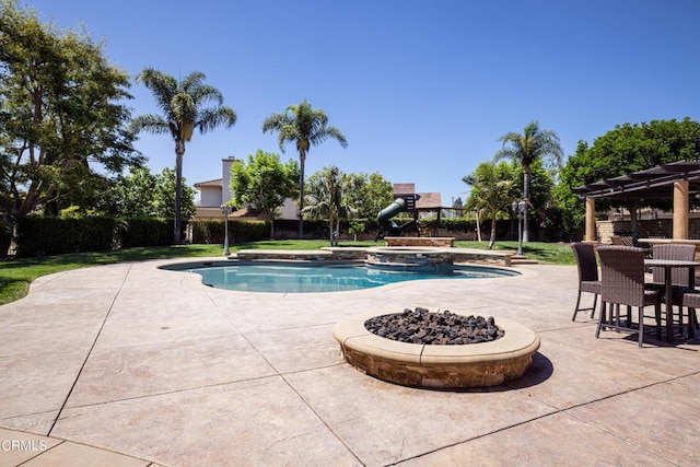 view of swimming pool featuring a patio and an outdoor fire pit