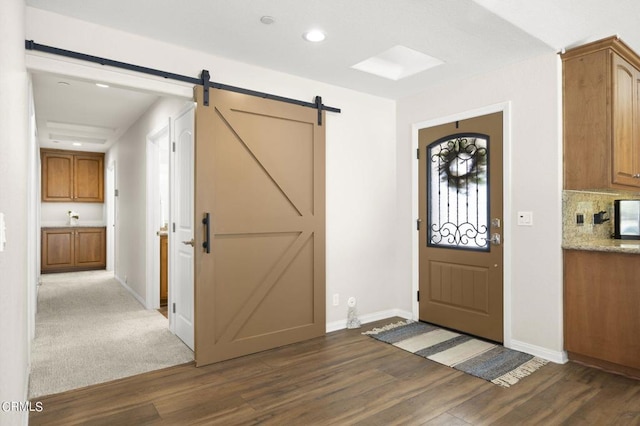 entryway featuring a barn door and dark wood-type flooring