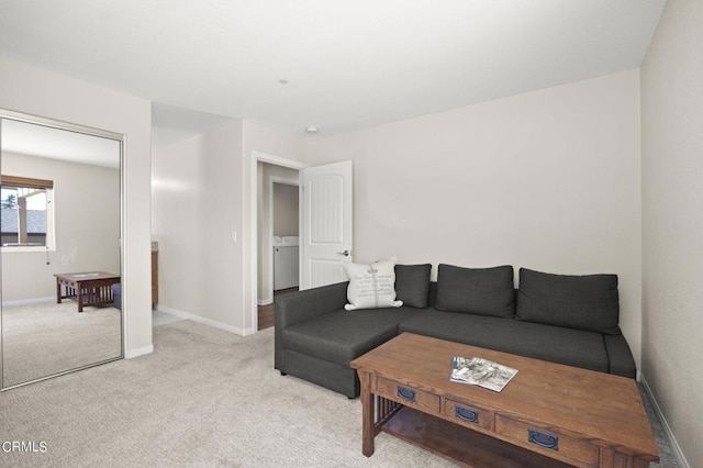 carpeted living room featuring washer / dryer