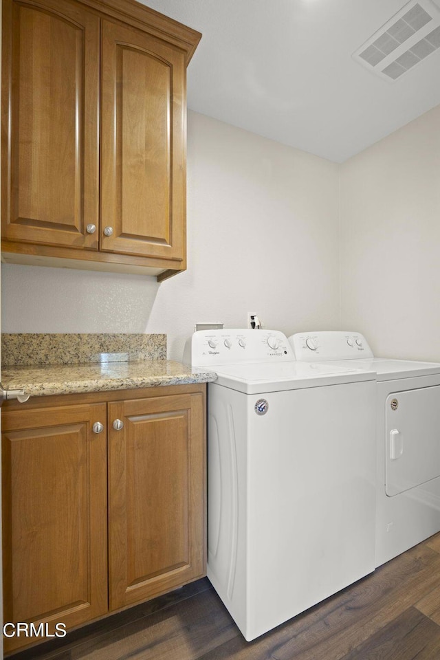 washroom with cabinets, dark hardwood / wood-style flooring, and separate washer and dryer