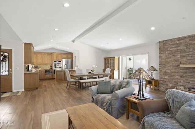 living room featuring vaulted ceiling with beams and light hardwood / wood-style flooring