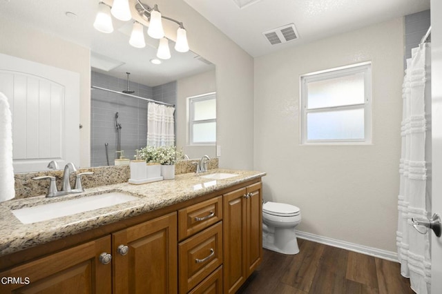 bathroom with a shower with curtain, vanity, wood-type flooring, and toilet