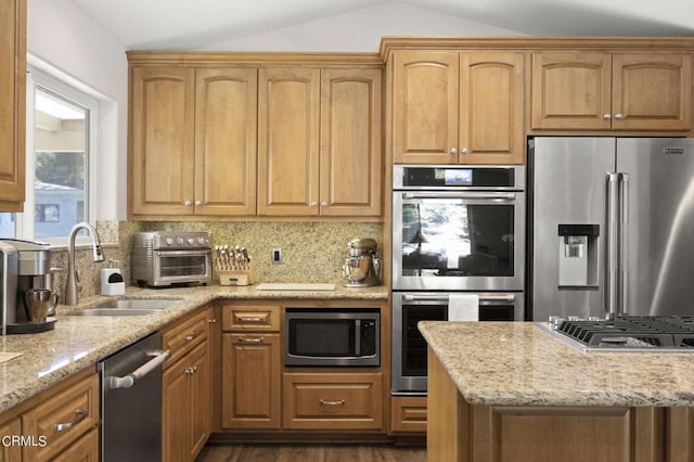 kitchen featuring tasteful backsplash, light stone counters, stainless steel appliances, and vaulted ceiling