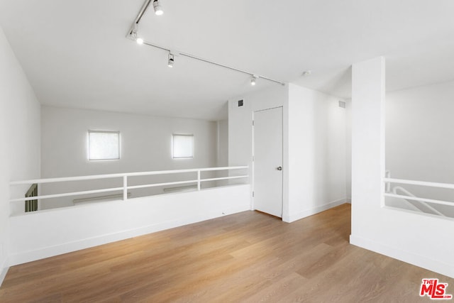 spare room featuring light hardwood / wood-style floors and track lighting