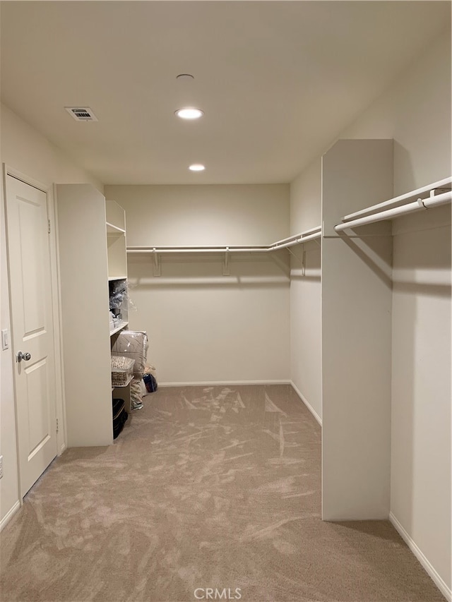 spacious closet featuring light carpet