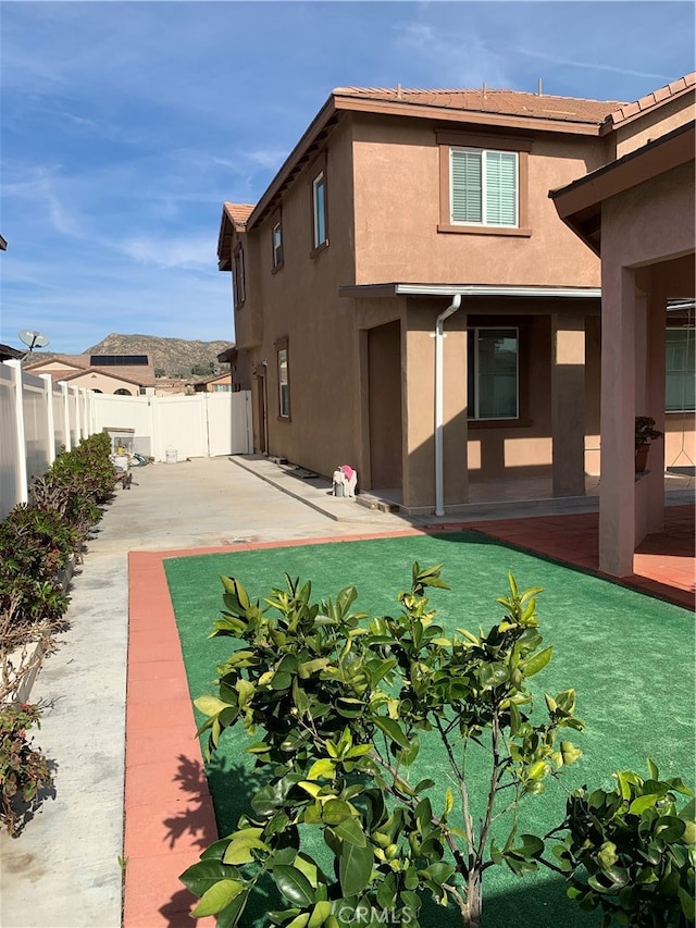 rear view of property featuring a yard and a patio