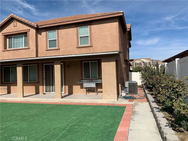 rear view of property with central air condition unit and a patio