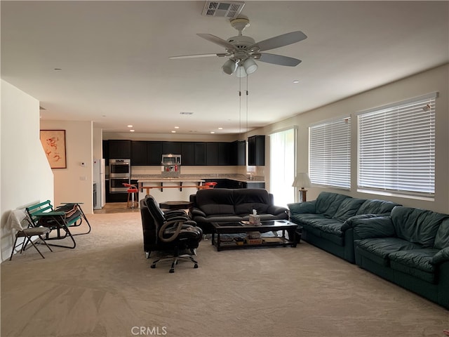 living room with light carpet and ceiling fan