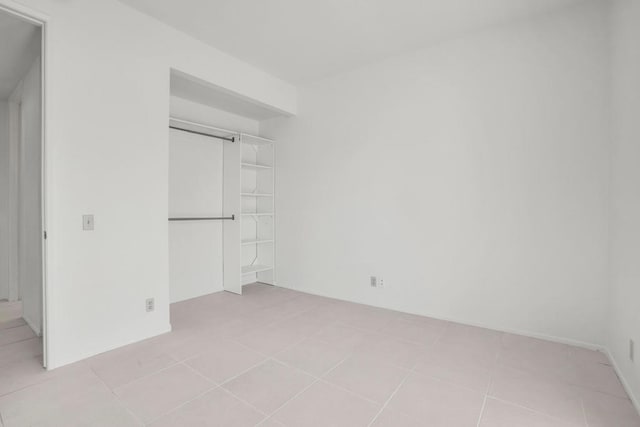 unfurnished bedroom with a closet and light tile patterned floors