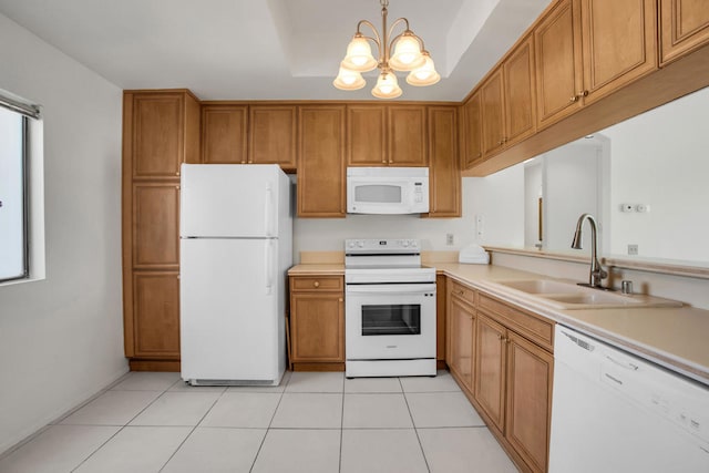 kitchen with light tile patterned flooring, sink, a notable chandelier, hanging light fixtures, and white appliances