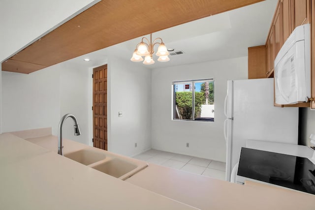 kitchen with sink, light tile patterned floors, decorative light fixtures, range, and a notable chandelier