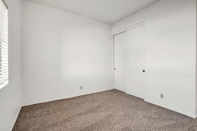 unfurnished bedroom with a closet, carpet, and multiple windows