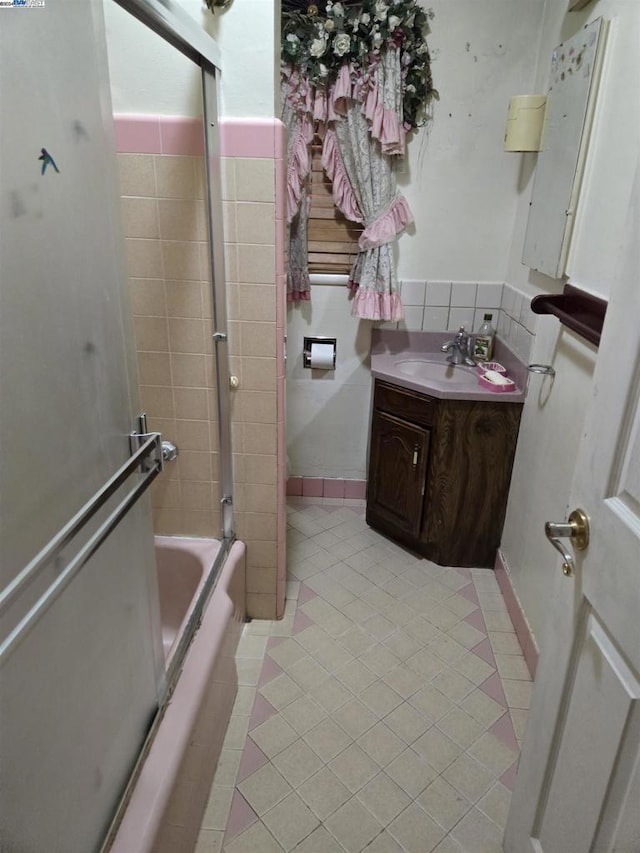 bathroom featuring tile patterned flooring, vanity, and tiled shower / bath