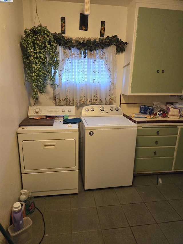 clothes washing area with dark tile patterned floors and washing machine and clothes dryer