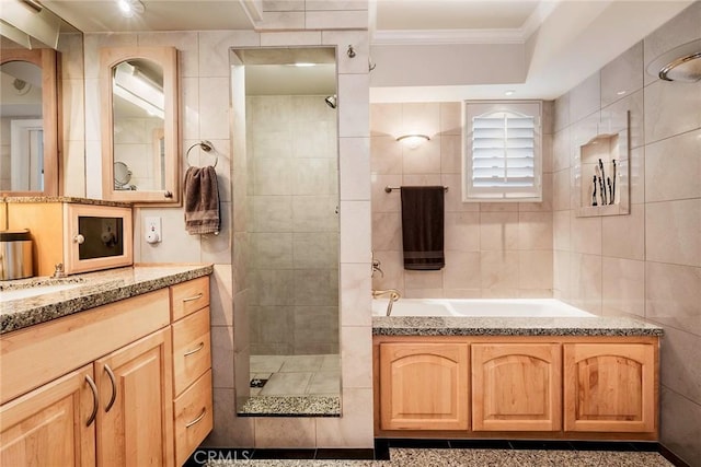 bathroom featuring vanity, tile walls, a shower, and crown molding