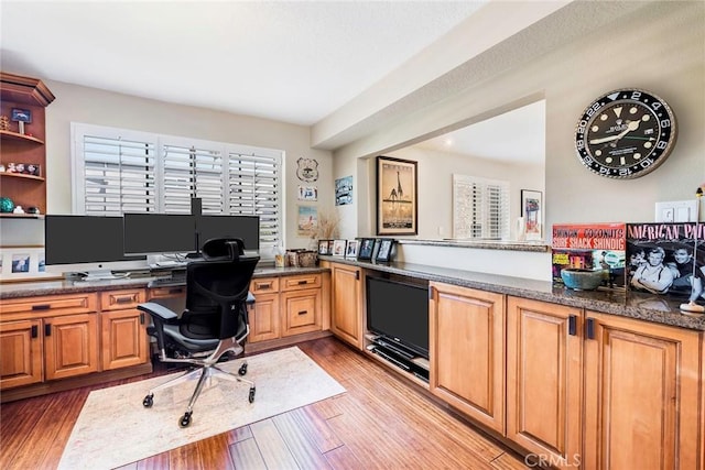 office featuring light hardwood / wood-style flooring and built in desk